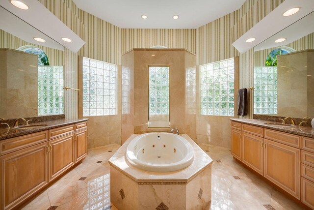 bathroom featuring tiled tub and vanity