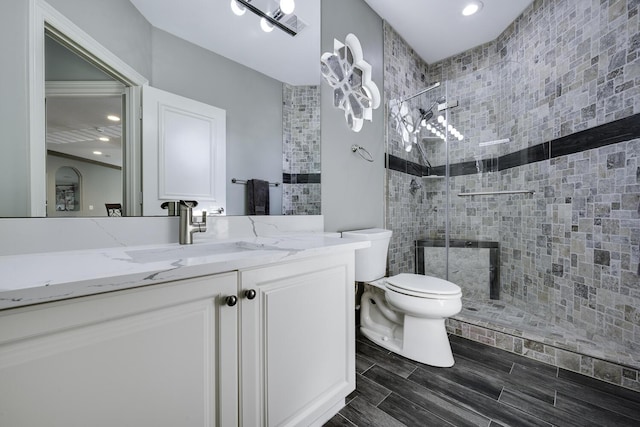 bathroom featuring vanity, toilet, and a tile shower