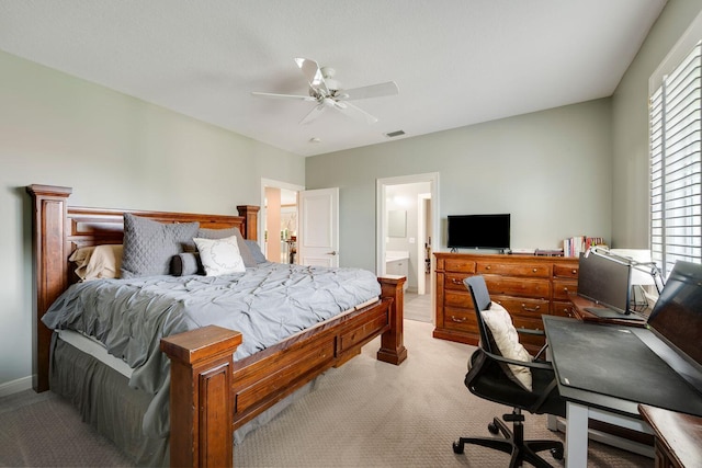 bedroom featuring light carpet, ensuite bath, multiple windows, and ceiling fan