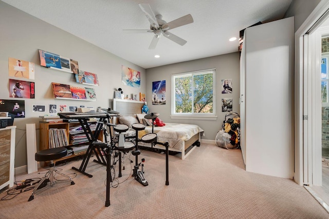 bedroom featuring ceiling fan, light carpet, and a textured ceiling