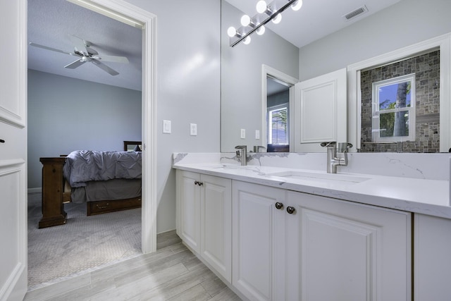 bathroom with ceiling fan, wood-type flooring, vanity, and a textured ceiling