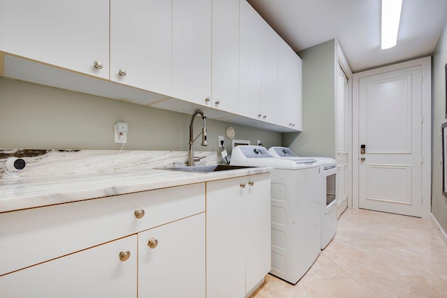 washroom featuring cabinets, washer and dryer, sink, and light tile patterned floors