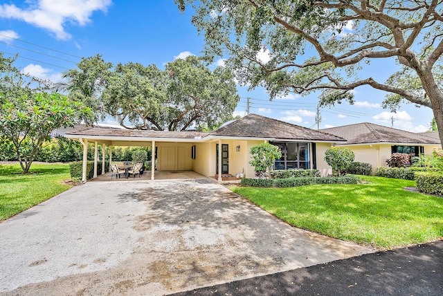 ranch-style home featuring a front lawn and a carport