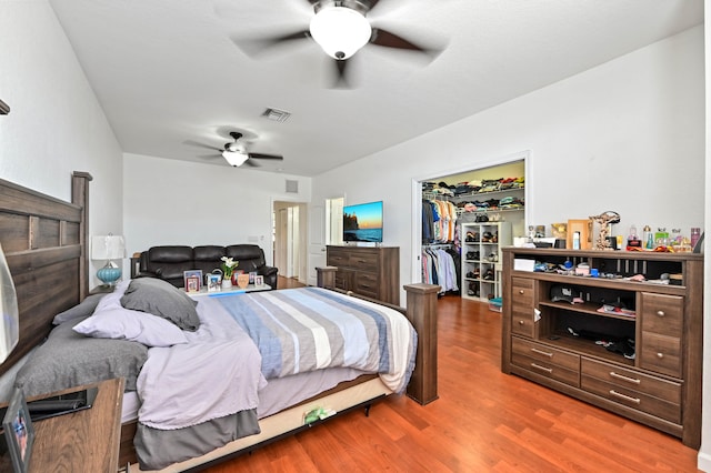 bedroom featuring a closet, ceiling fan, hardwood / wood-style flooring, and a walk in closet