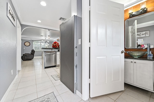 hallway with ornamental molding, sink, and light tile patterned floors