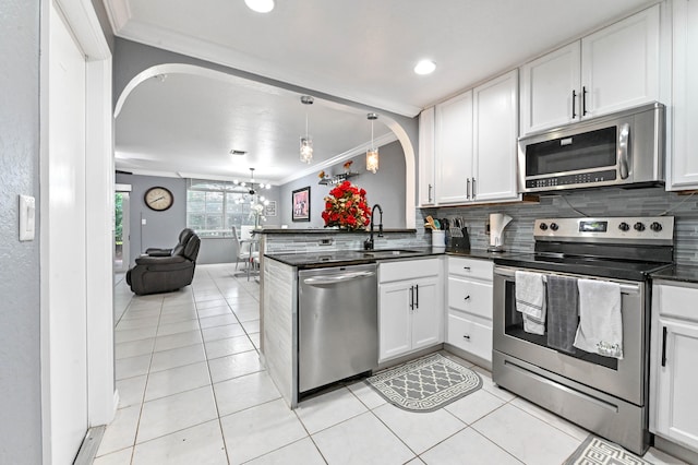 kitchen with white cabinetry, appliances with stainless steel finishes, sink, and kitchen peninsula