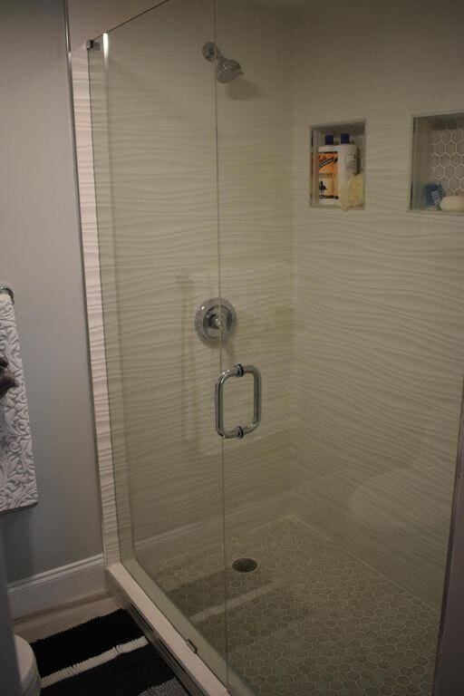 bathroom featuring a shower with door