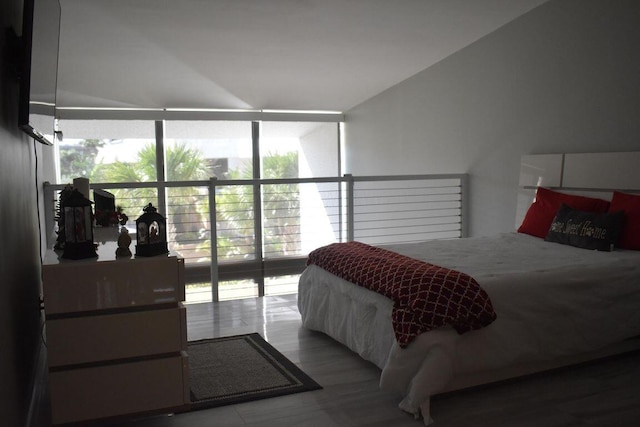 bedroom with hardwood / wood-style flooring and expansive windows