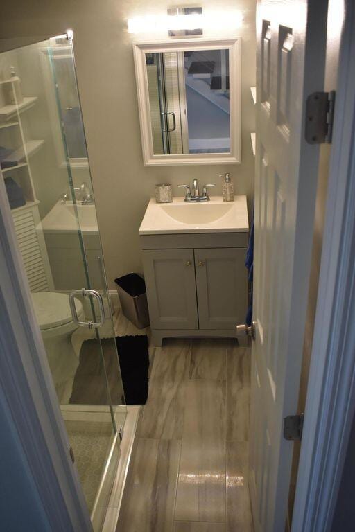 bathroom with vanity, toilet, and an enclosed shower