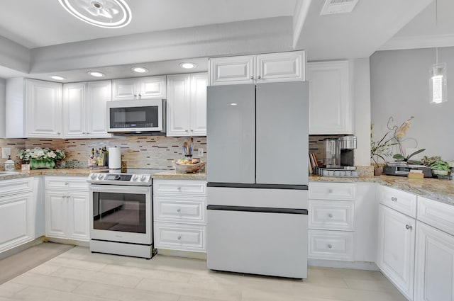 kitchen featuring light stone counters, white cabinets, backsplash, and white appliances