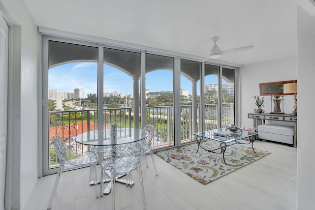 interior space with plenty of natural light, ceiling fan, and a wall of windows