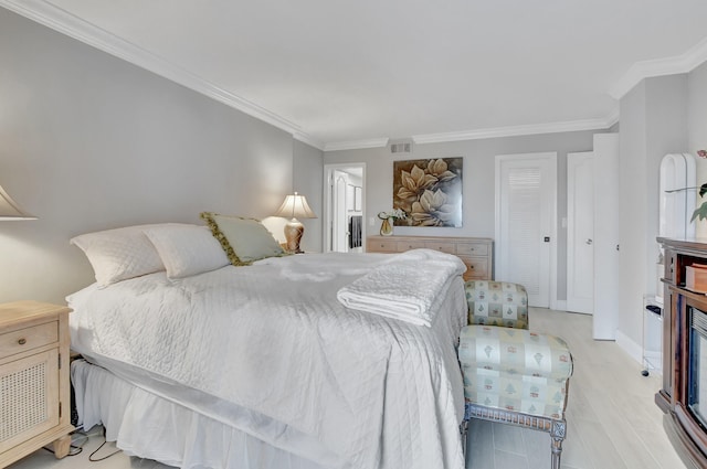 bedroom with light hardwood / wood-style floors and crown molding