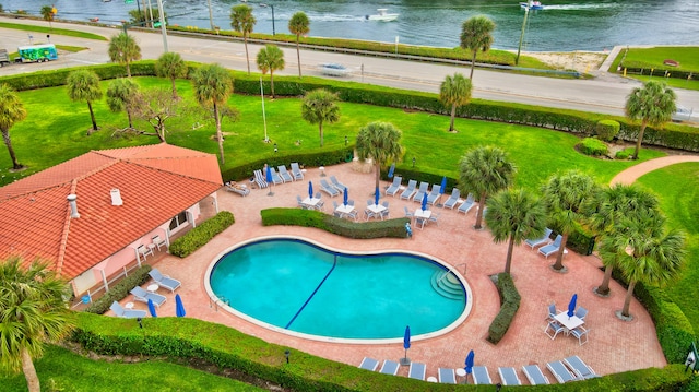 view of pool with a yard and a water view