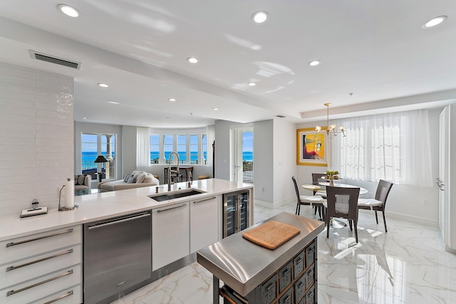 kitchen with beverage cooler, sink, pendant lighting, dishwasher, and white cabinetry