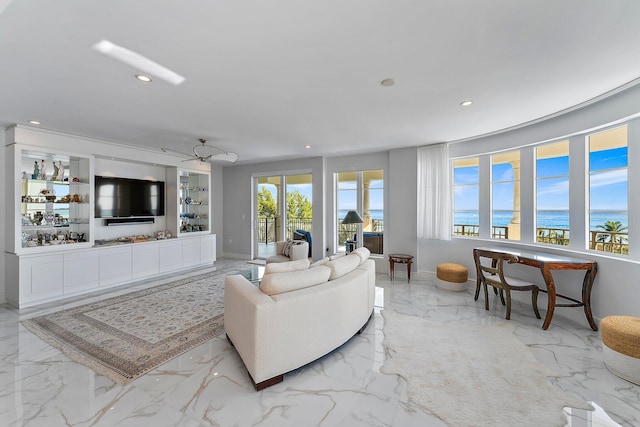 living room featuring ceiling fan and a water view