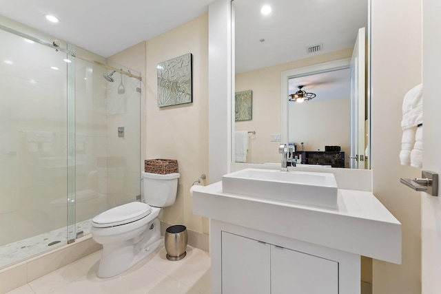 bathroom with tile patterned flooring, vanity, toilet, and walk in shower