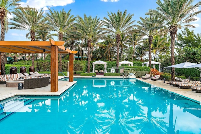 view of swimming pool featuring an outdoor living space with a fire pit and a patio