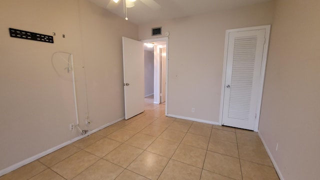 unfurnished bedroom with ceiling fan and light tile patterned floors