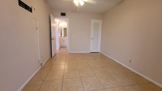 tiled spare room with ceiling fan