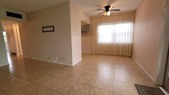 spare room with ceiling fan and light tile patterned floors