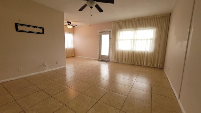 spare room with ceiling fan and light tile patterned floors