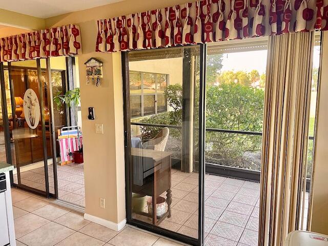 doorway to outside with light tile patterned floors