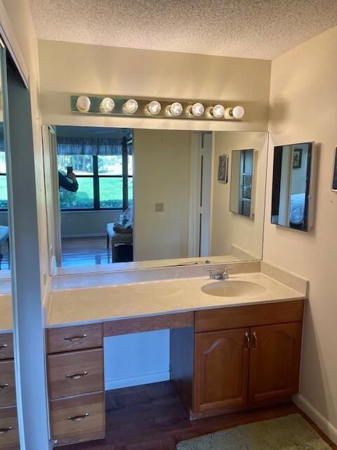 bathroom featuring a textured ceiling, hardwood / wood-style flooring, and vanity