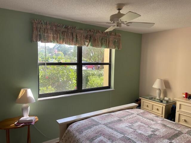 bedroom with a textured ceiling and ceiling fan