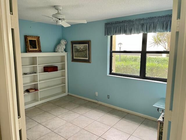 unfurnished room featuring ceiling fan, a textured ceiling, and light tile patterned floors