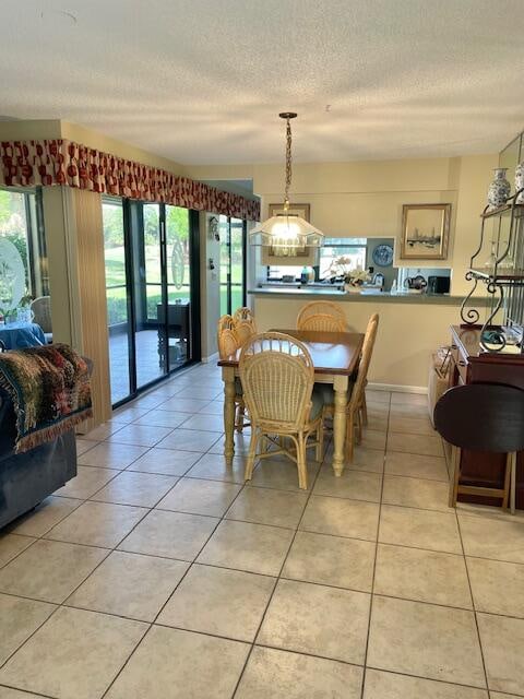 tiled dining space featuring a textured ceiling