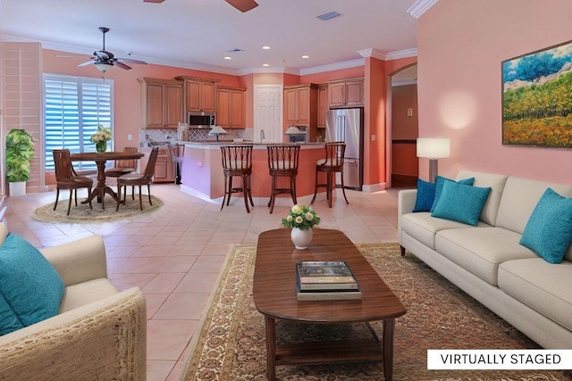 tiled living room featuring crown molding and ceiling fan