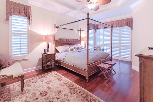 bedroom featuring multiple windows, hardwood / wood-style floors, ornamental molding, and ceiling fan