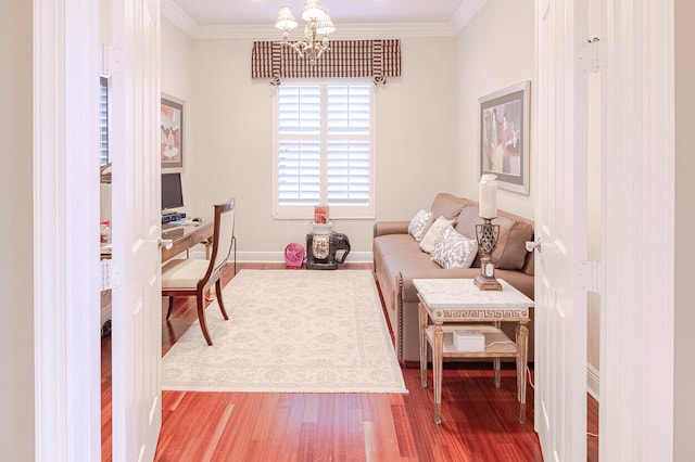 living area with hardwood / wood-style floors, ornamental molding, and a chandelier