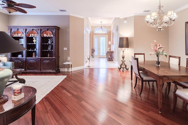 dining area featuring ornamental molding, ceiling fan with notable chandelier, and wood-type flooring