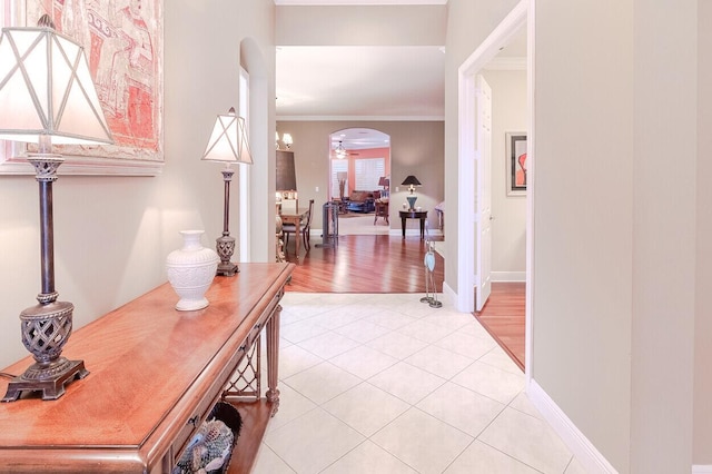 hallway featuring crown molding and light tile patterned floors