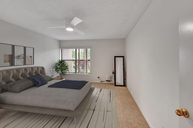 bedroom featuring ceiling fan, a textured ceiling, and carpet flooring