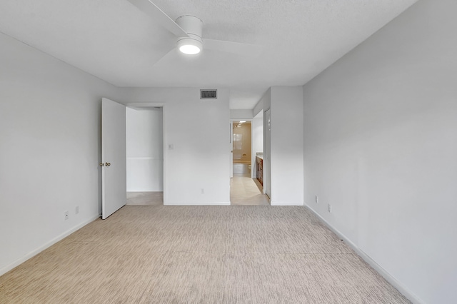 unfurnished bedroom with ceiling fan, light carpet, and ensuite bath