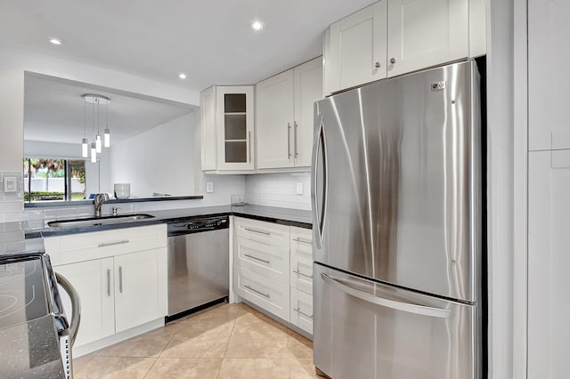 kitchen with sink, light tile patterned floors, hanging light fixtures, stainless steel appliances, and white cabinets