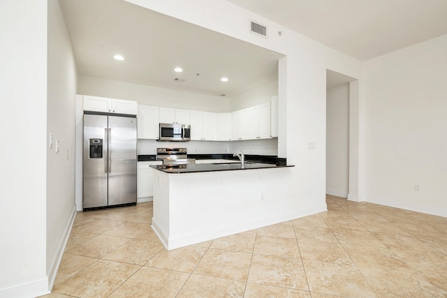 kitchen featuring appliances with stainless steel finishes, white cabinetry, sink, kitchen peninsula, and light tile patterned flooring