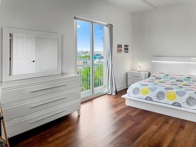 bedroom featuring dark hardwood / wood-style flooring and access to outside