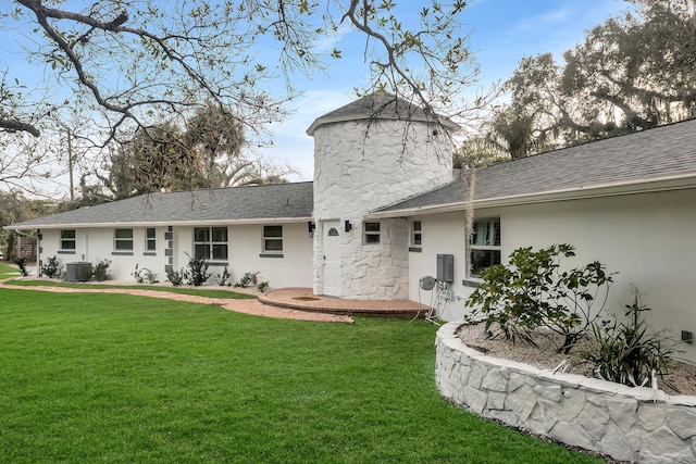 back of house with a yard and central AC