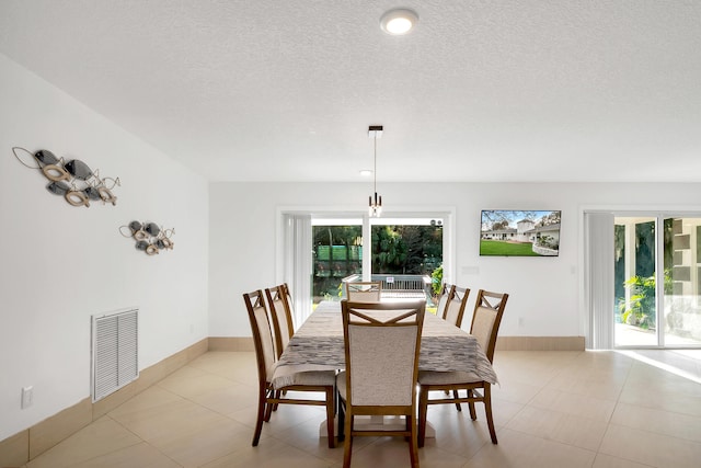 dining space with a wealth of natural light and a textured ceiling