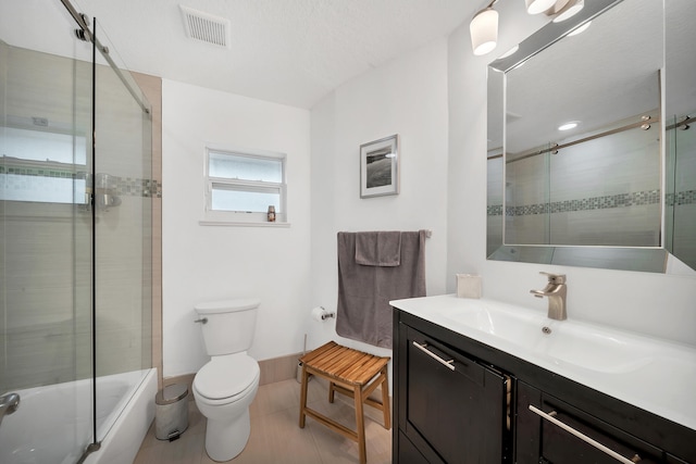 full bathroom featuring tile patterned flooring, vanity, toilet, and bath / shower combo with glass door