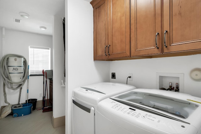 laundry area featuring independent washer and dryer and cabinets