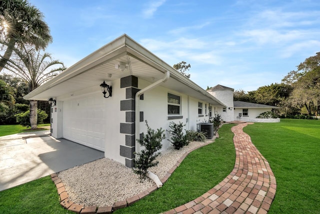 single story home with central air condition unit, a garage, and a front yard