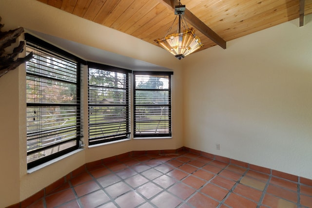 spare room with tile patterned floors, beamed ceiling, baseboards, and wooden ceiling