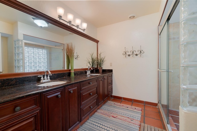 bathroom featuring tile patterned floors, a shower with door, and vanity