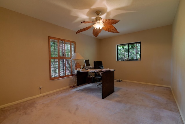 carpeted home office featuring ceiling fan