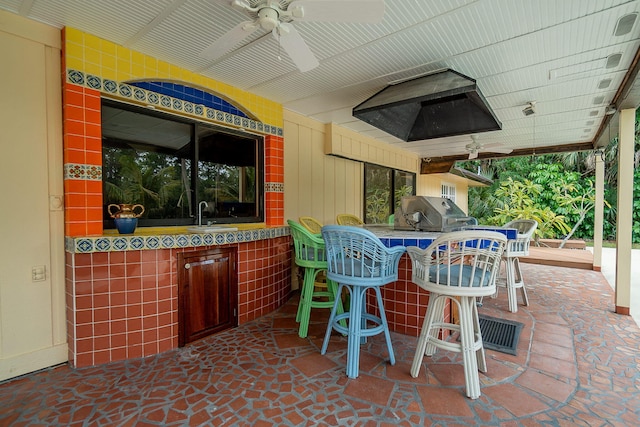 view of patio / terrace featuring outdoor dry bar, a grill, ceiling fan, and a sink