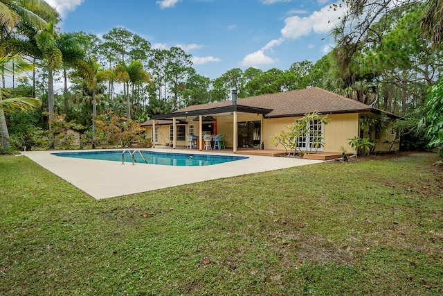 pool featuring a patio and a lawn